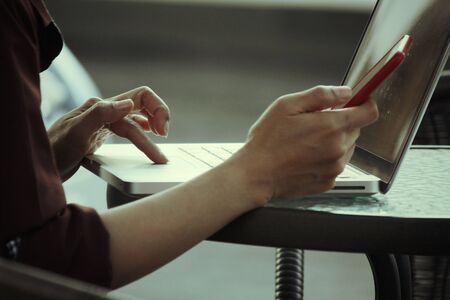 Woman using smart phone with computerの写真素材