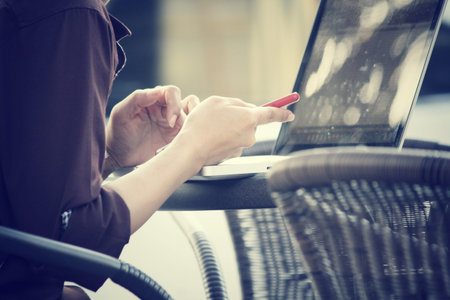 Woman using smart phone with computer