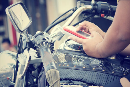 Using smart phone with motorcycleの写真素材