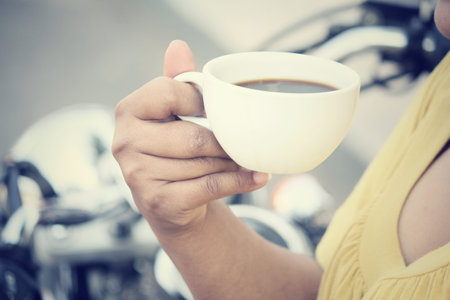 Woman drinking coffee with motorcycle