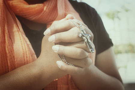 Woman hands praying with crossの写真素材