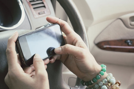 Woman using smart phone in the car.