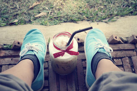 Iced coffee with sneakersの写真素材