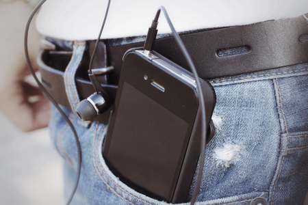 Woman listening to music on earphone with smart phoneの写真素材