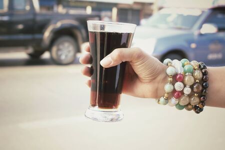 Woman drinking a cola at roadの写真素材