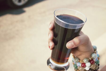 Woman drinking a cola at roadの写真素材