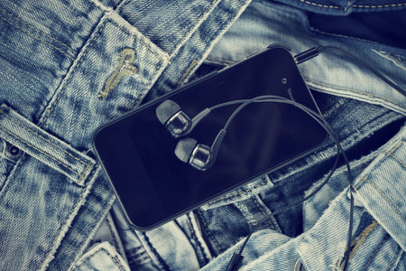 Earphone and smartphone with jeansの写真素材