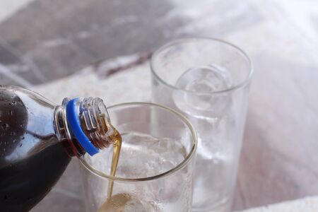 Glass of cola with ice cubesの写真素材