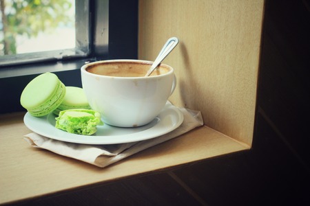 Green macaroons with coffee cupの写真素材