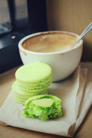 Green macaroons with coffee cupの写真素材