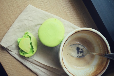 Green macaroons with coffee cupの写真素材