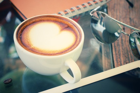 Coffee cup and tablet with sun glassesの写真素材