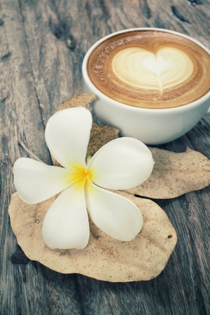 Vintage latte art coffee with flowerの写真素材