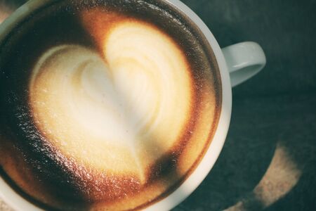 Vintage latte art coffee with shadowの写真素材