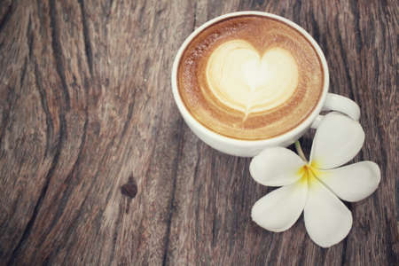 Vintage latte art coffee with flowerの写真素材