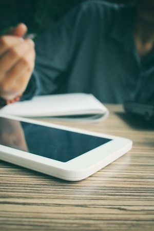 Woman with pen on paper and laptopの写真素材