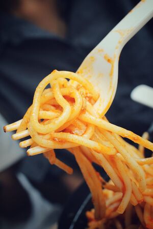 Woman eating spaghetti with sauceの写真素材