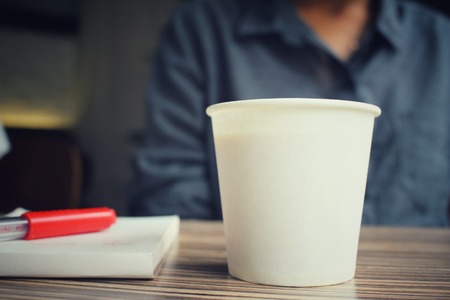 Woman with pen on paper and coffee cupの写真素材