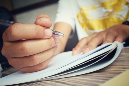 Woman with pen writing on paperの写真素材