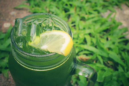 Ice green tea with lemon on a jar