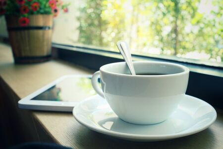 Hot coffee with tablet at cafeの写真素材