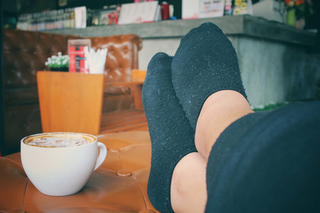 Latte art coffee with feet relaxingの写真素材