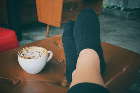 Latte art coffee with feet relaxingの写真素材
