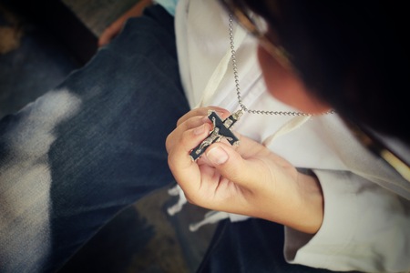 Hands praying with crossの写真素材