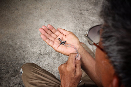 Senior man hands praying with crossの写真素材