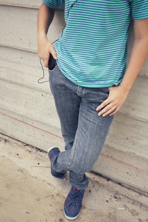 Young woman listening to music on earphone with smart phone