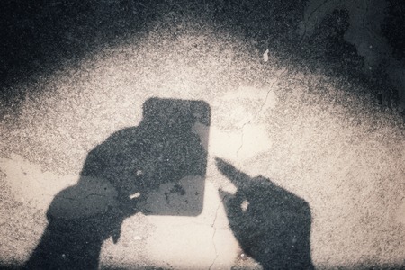 Shadow of using smart phoneの写真素材