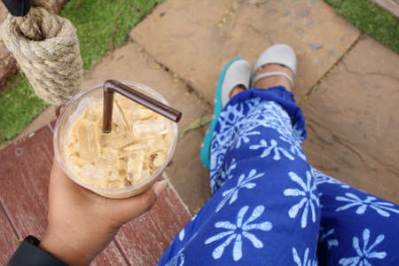 Selfie of iced coffee with shoesの写真素材