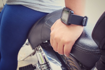 Woman hand with smartwatch on motorcycleの写真素材
