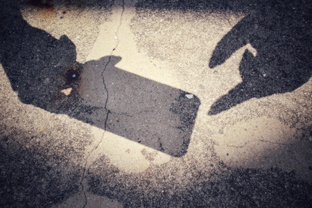 Shadow of using smart phoneの写真素材