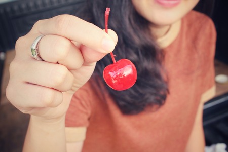 Young woman eating cherriesの写真素材