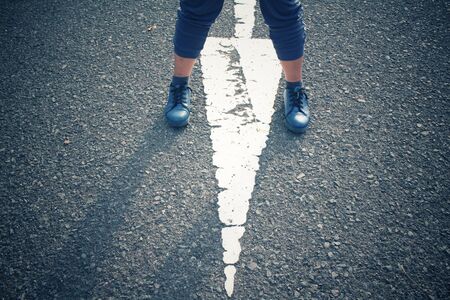 Sneakers with arrow on roadの写真素材