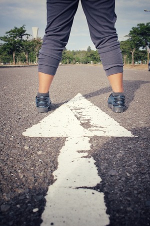 Sneakers with arrow on roadの写真素材