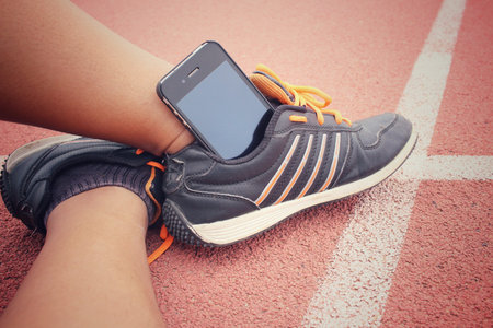 Sport shoes with smart phone on track