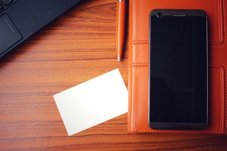 Blank business card with smart phone at officeの写真素材