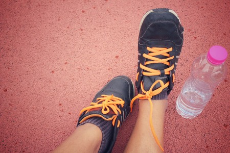 Sport shoes with water drink on trackの写真素材