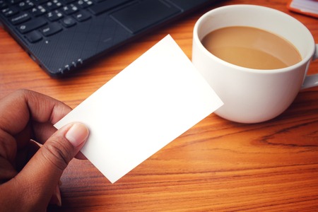 Coffee cup with blank business card at officeの写真素材