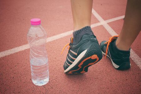 Woman with shoes running on trackの写真素材