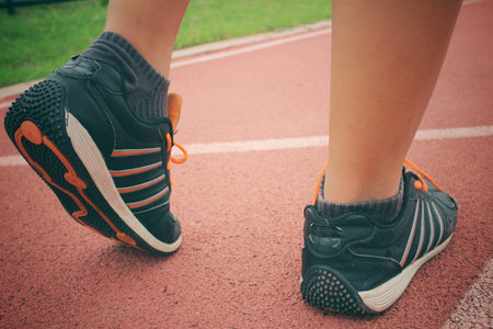 Woman with shoes running on track