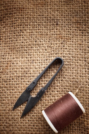 Sewing threads with scissors on sackclothの写真素材