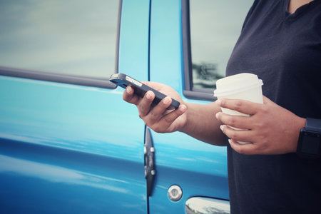 Woman using smart phone with coffee paper cup