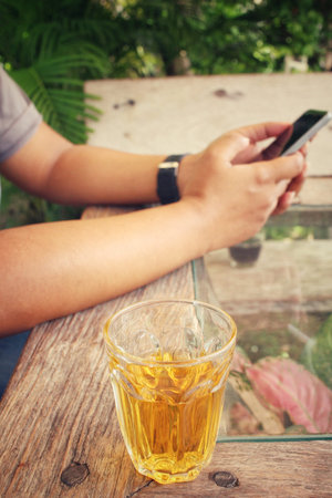 Woman using smart phone with hot teaの写真素材
