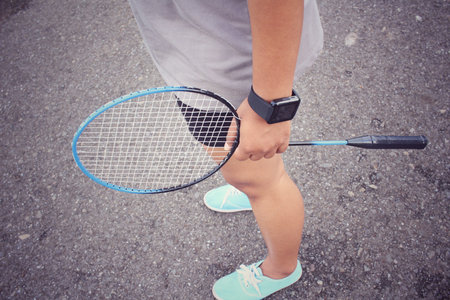 Young female with shuttlecocks and badminton racket.