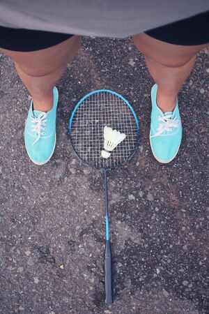 Selfie of sneakers with shuttlecocks and badminton racket.の写真素材