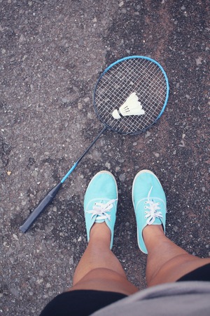Selfie of sneakers with shuttlecocks and badminton racket.の写真素材