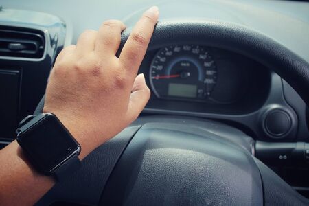 Woman hands drive a car with smartwatchの写真素材